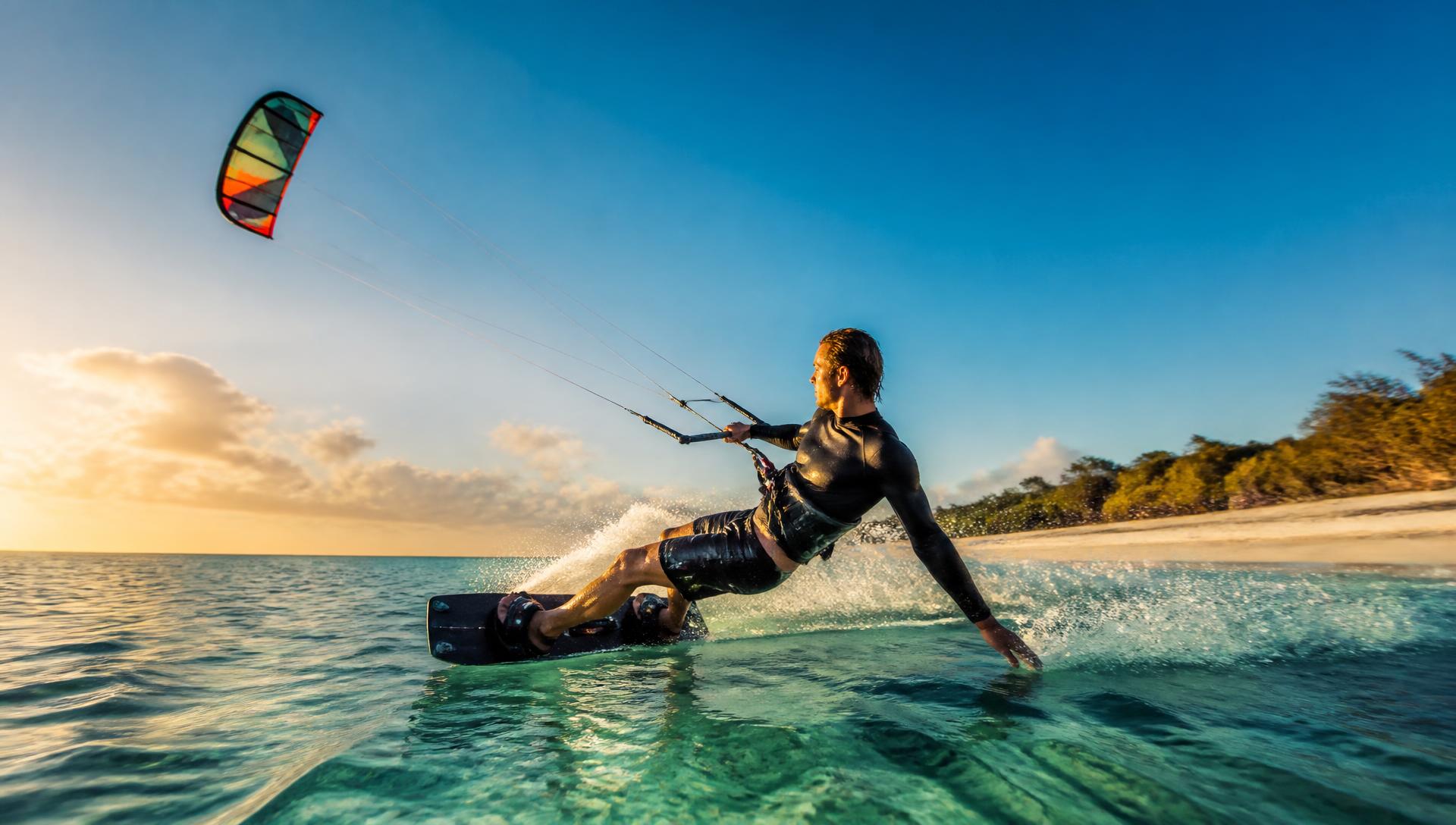 Kitesurfer riding across turquoise water at Elliott Heads